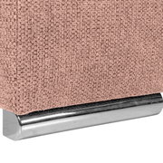 Nahaufnahme einer rosa strukturierten Stoffoberfläche mit einem silbernen Metallfuß, perspektivisch von der Seite aufgenommen.