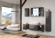 Modernes Badezimmer mit Spiegelpaneel, Waschtisch und Schränken in dunklem Holzdesign, seitliche Perspektive.