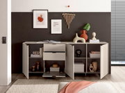 Modern wit dressoir met open deuren en lades, versierd met vazen, boeken en wanddecoraties; vooraanzicht in de woonkamer.