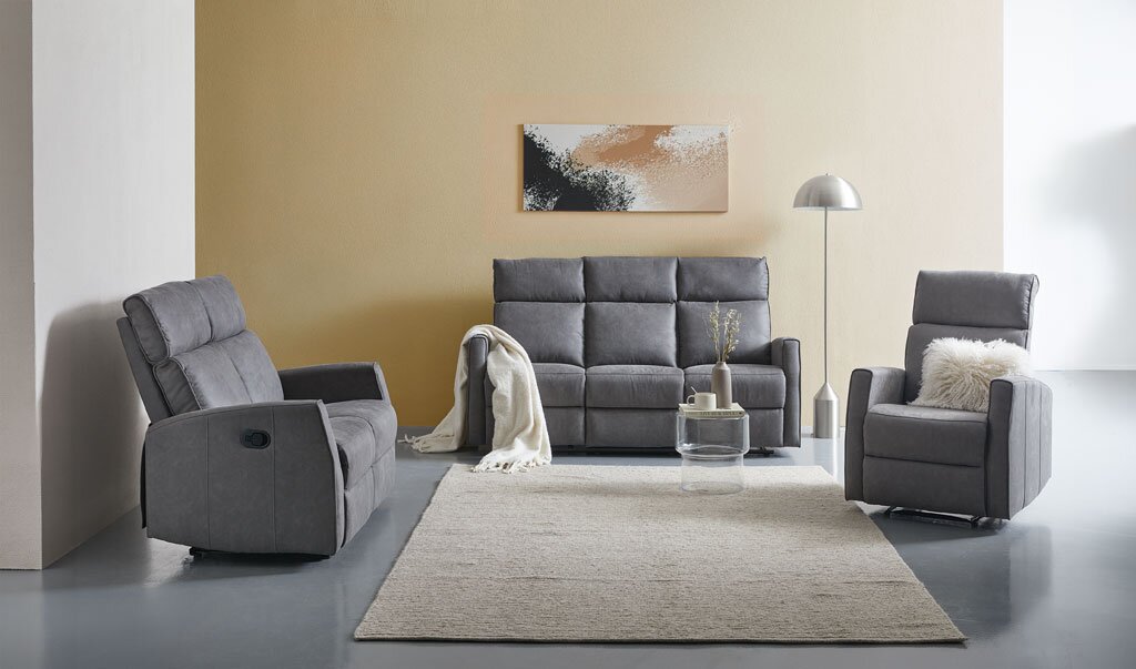 Graue Polstergarnitur mit Dreisitzer-Sofa und zwei Relaxsesseln in einem modernen Wohnzimmer, frontal aus leicht erhöhter Perspektive präsentiert