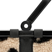 Nahaufnahme von oben auf den schwarzen Tragegriff und die Befestigung einer reisenthel Tasche mit Klettschlaufen und beigem Teddy-Stoffmuster