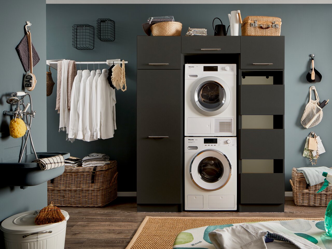 XORA Doppel-Geräteschrank PRIMUS Moderner Waschraum mit einem schwarzen Hochschrank, der eine Waschmaschine und einen Trockner enthält. Perspektive von vorne.