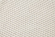 Nahaufnahme eines cremefarbenen, gerippten Stoffes in diagonaler Perspektive.