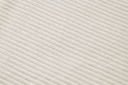 Nahaufnahme eines cremefarbenen, gerippten Stoffes in diagonaler Perspektive.
