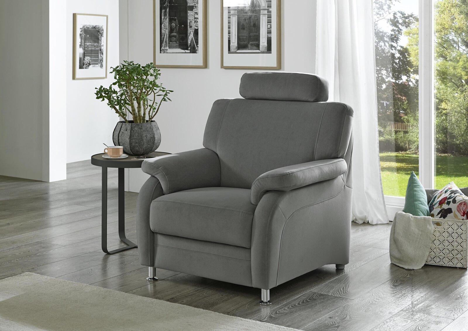 Grauer Sessel mit Kopfstütze in einem modernen Wohnzimmer, seitliche Perspektive