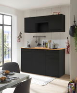 Moderne Single-Küche in schwarzem Design mit Holzarbeitsplatte, fotografiert aus einer leicht seitlichen Perspektive.