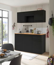 Moderne Single-Küche in schwarzem Design mit Holzarbeitsplatte, fotografiert aus einer leicht seitlichen Perspektive.