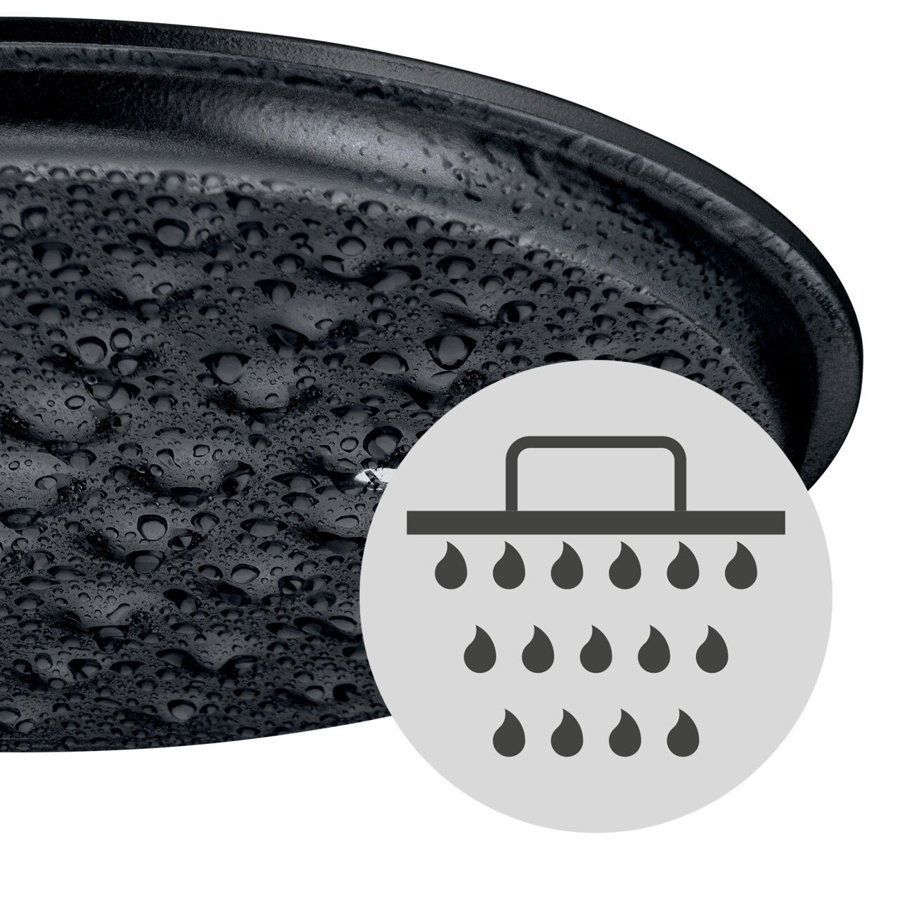 Nahaufnahme eines WMF Flavour ovalen Bräters 33x26cm mit Wassertropfen auf der Oberfläche und einem Symbol für gleichmäßige Feuchtigkeitsverteilung.