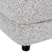 Nahaufnahme eines Big-Sofas mit strukturiertem Stoffbezug und schwarzem Fuß, seitliche Perspektive.