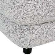 Nahaufnahme eines Big-Sofas mit strukturiertem Stoffbezug und schwarzem Fuß, seitliche Perspektive.