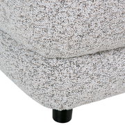 Nahaufnahme eines Big-Sofas mit strukturiertem Stoffbezug und schwarzem Fuß, seitliche Perspektive.