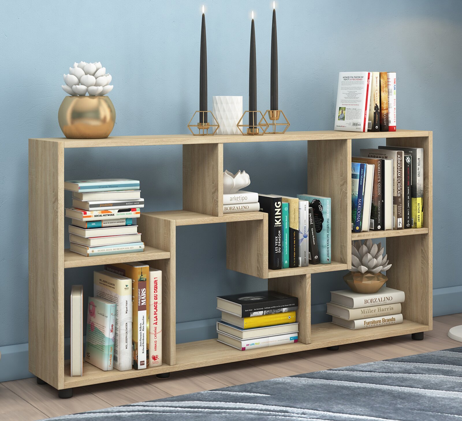 Modernes, offenes Bücherregal in heller Eiche-Optik mit asymmetrischen Fächern, dekoriert mit Büchern, Kerzenständern und Pflanzen, Frontansicht in leicht schräger Perspektive.