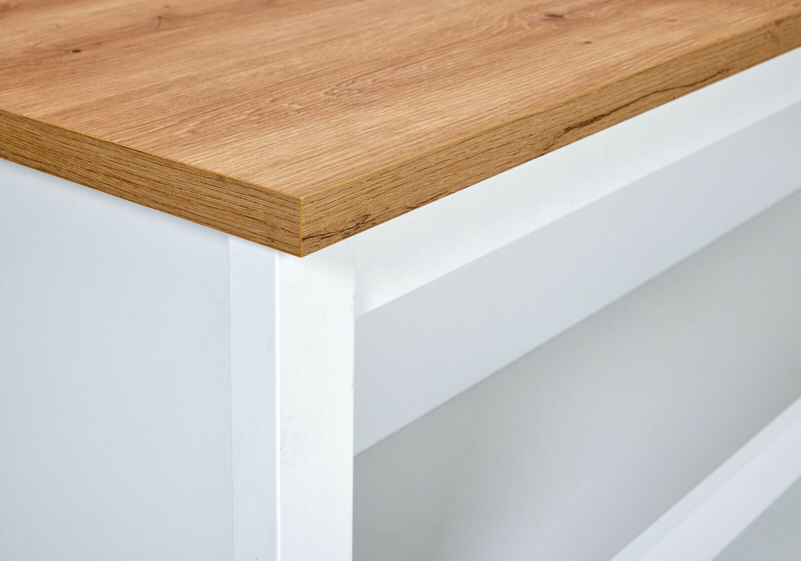 Nahaufnahme einer Kücheninsel mit weißem Korpus und Holzarbeitsplatte, Perspektive von der Seite.