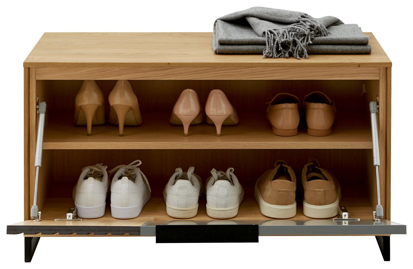Garderobenbank aus Holz mit zwei Regalböden, auf denen verschiedene Schuhe stehen. Oben liegt eine gefaltete graue Decke. Frontale Perspektive.