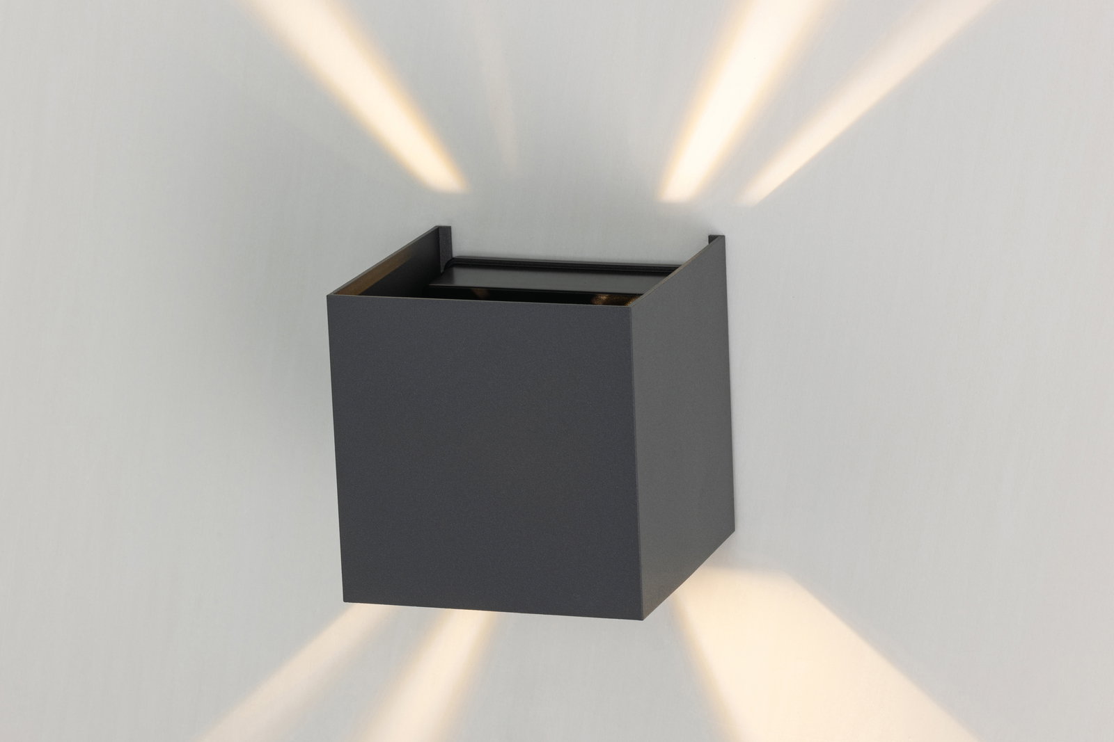 Moderne LED-Wandleuchte in Würfelform, die warmes Licht nach oben und unten abstrahlt, seitliche Perspektive