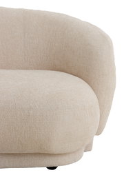 Nahaufnahme einer beigen Couch mit abgerundeten Ecken und strukturierter Oberfläche, seitliche Perspektive