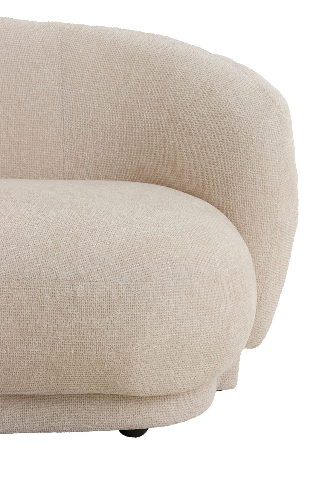 Nahaufnahme einer beigen Couch mit abgerundeten Ecken und strukturierter Oberfläche, seitliche Perspektive