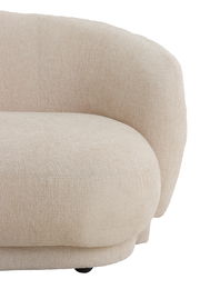 Nahaufnahme einer beigen Couch mit abgerundeten Ecken und strukturierter Oberfläche, seitliche Perspektive