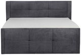 Frontale Ansicht eines grauen Boxspringbetts mit gepolstertem Kopfteil.