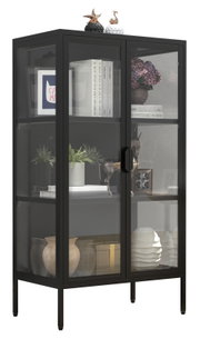 Schwarzer Vitrinenschrank mit Glasfront und Metallrahmen, gefüllt mit Deko und Büchern, in schräger Frontansicht (leicht von links)
