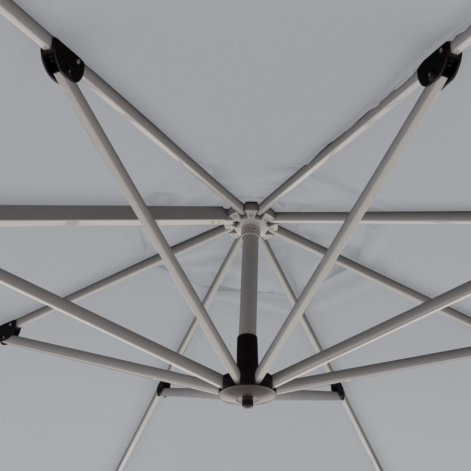 Ansicht von unten eines Pendelschirms mit stabilen Metallstreben und grauem Stoffbezug.