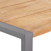 Nahaufnahme eines Gartentisches mit Holzplatte und Metallrahmen, Perspektive von oben auf die Ecke.