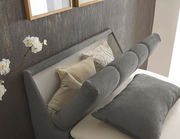 Boxspringbett mit grauem Kopfteil und Kissen, seitliche Perspektive