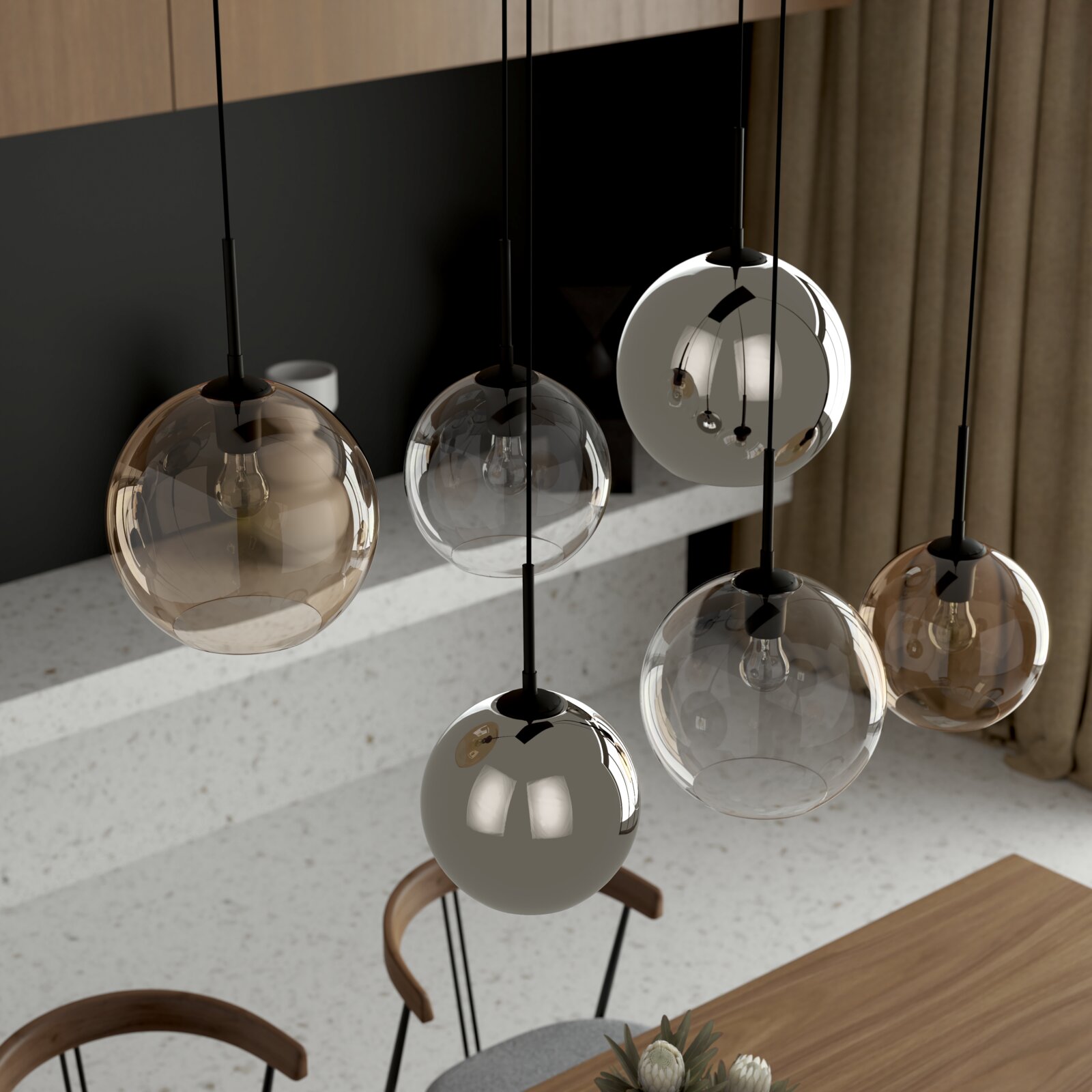 Moderne Pendelleuchten mit kugelförmigen Glas-Schirmen in Rauchgrau und Amber, hängend an schwarzen Kabeln über einem Esstisch, schräge Ansicht von leicht oben