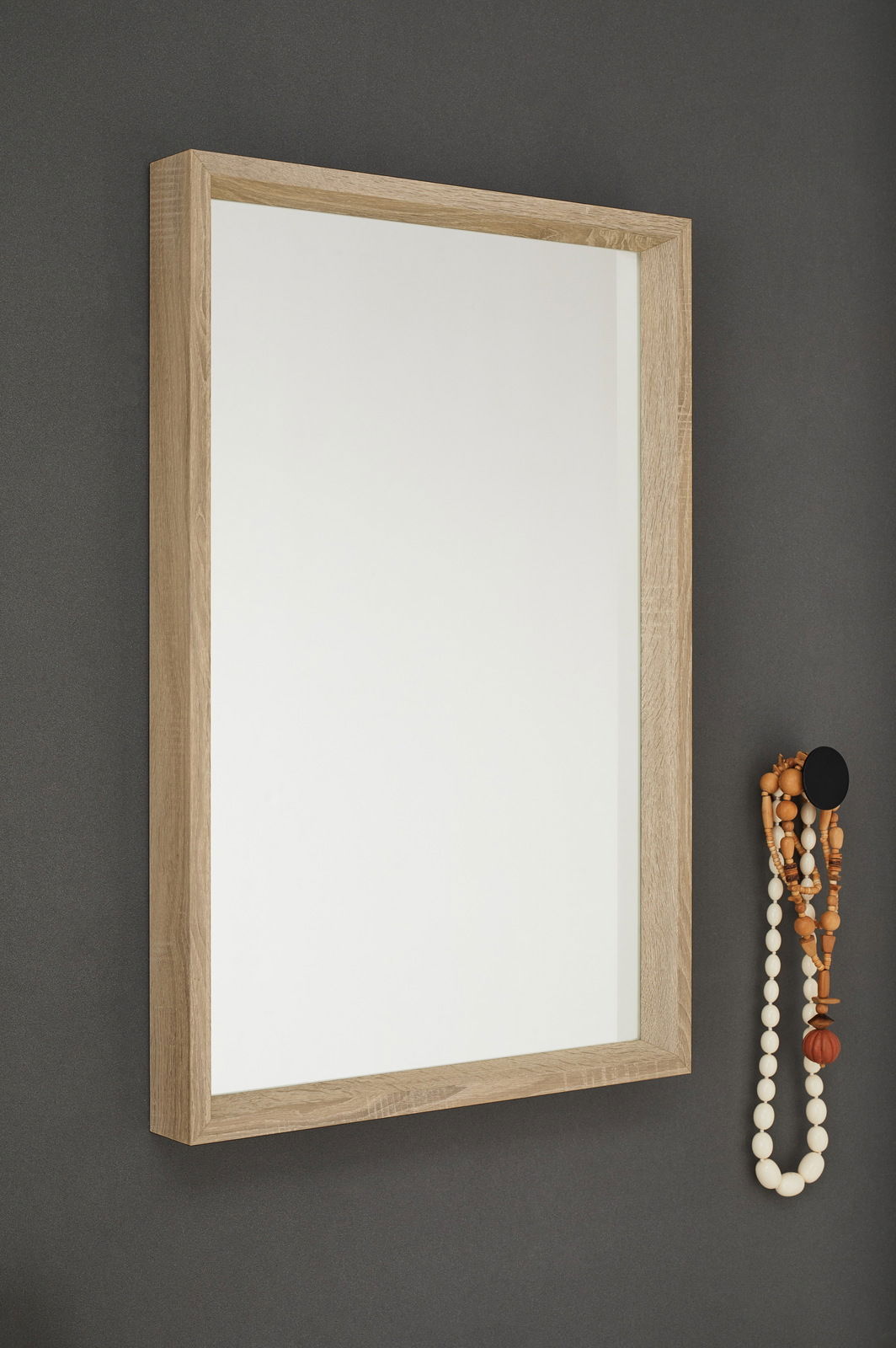 Rechteckiger Spiegel mit Holzrahmen, an einer grauen Wand montiert, seitliche Perspektive