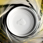 Bovenaanzicht van een geel Twist-drinkglas met spiraalvormig ontwerp.