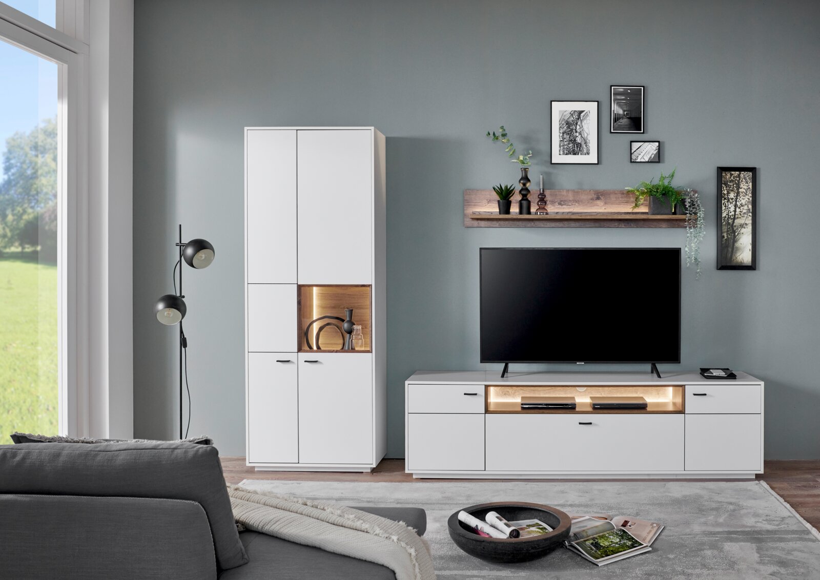 Moderne Wandkombination in Weiß mit TV-Schrank, Vitrine und Wandregal, frontal betrachtet.