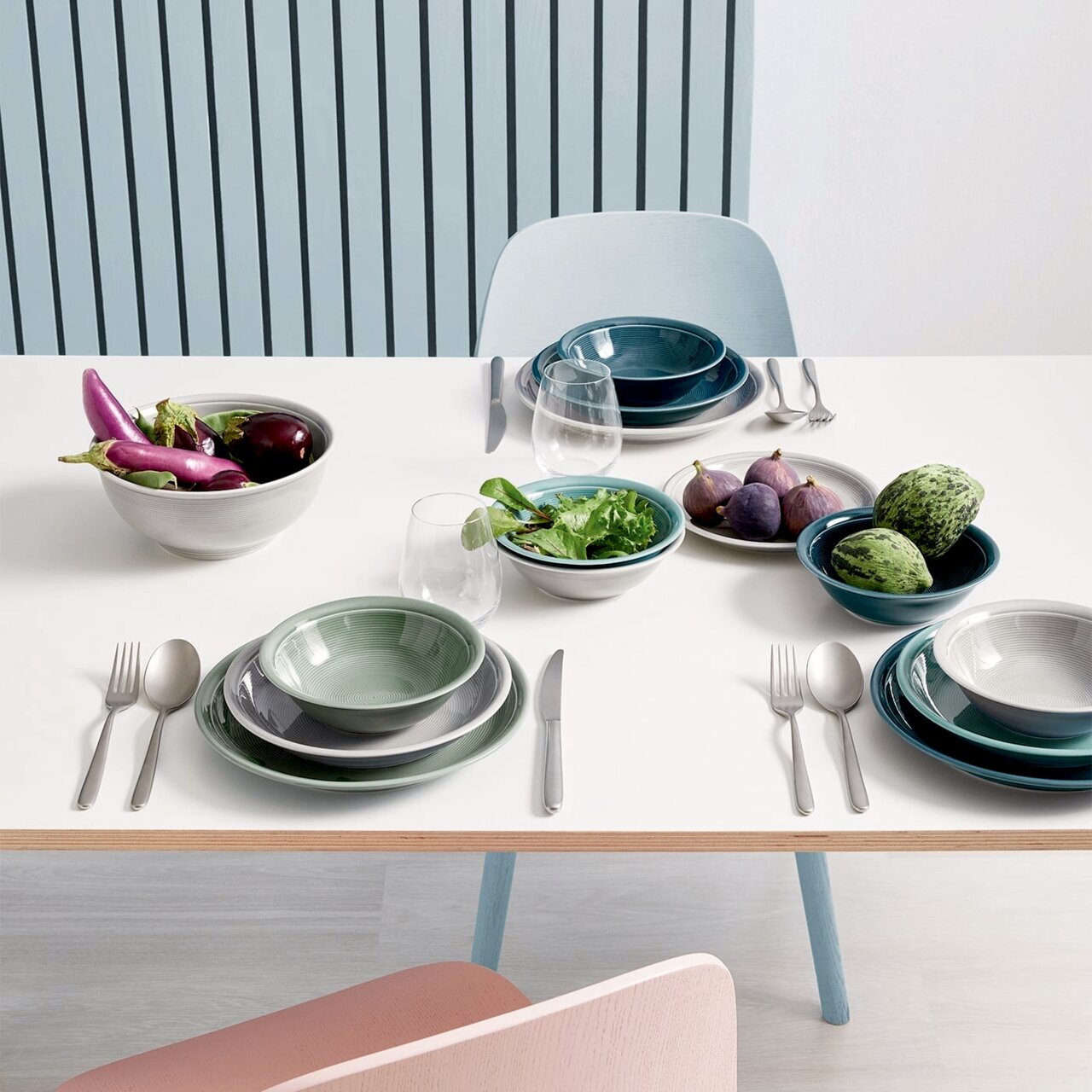 Frühstückstisch mit verschiedenen Tellern und Schalen in Moosgrün und anderen Farben, von oben fotografiert.