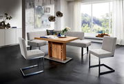 Moderne Essgruppe mit Eckbank und Freischwinger-Stühlen in einem hellen Raum mit großem Fenster, seitliche Perspektive.