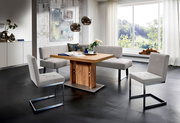 Moderne Essgruppe mit Eckbank und Freischwinger-Stühlen in einem hellen Raum mit großem Fenster, seitliche Perspektive.