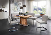 Moderne Essgruppe mit Eckbank und Freischwinger-Stühlen in einem hellen Raum mit großem Fenster, seitliche Perspektive.