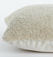 Nahaufnahme eines beigen Kissens mit flauschiger Textur, seitliche Perspektive