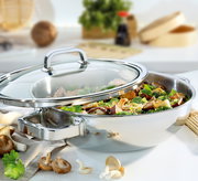 Wok mit Glasdeckel, gefüllt mit frischem Gemüse und Tofu, aus seitlicher Perspektive fotografiert.