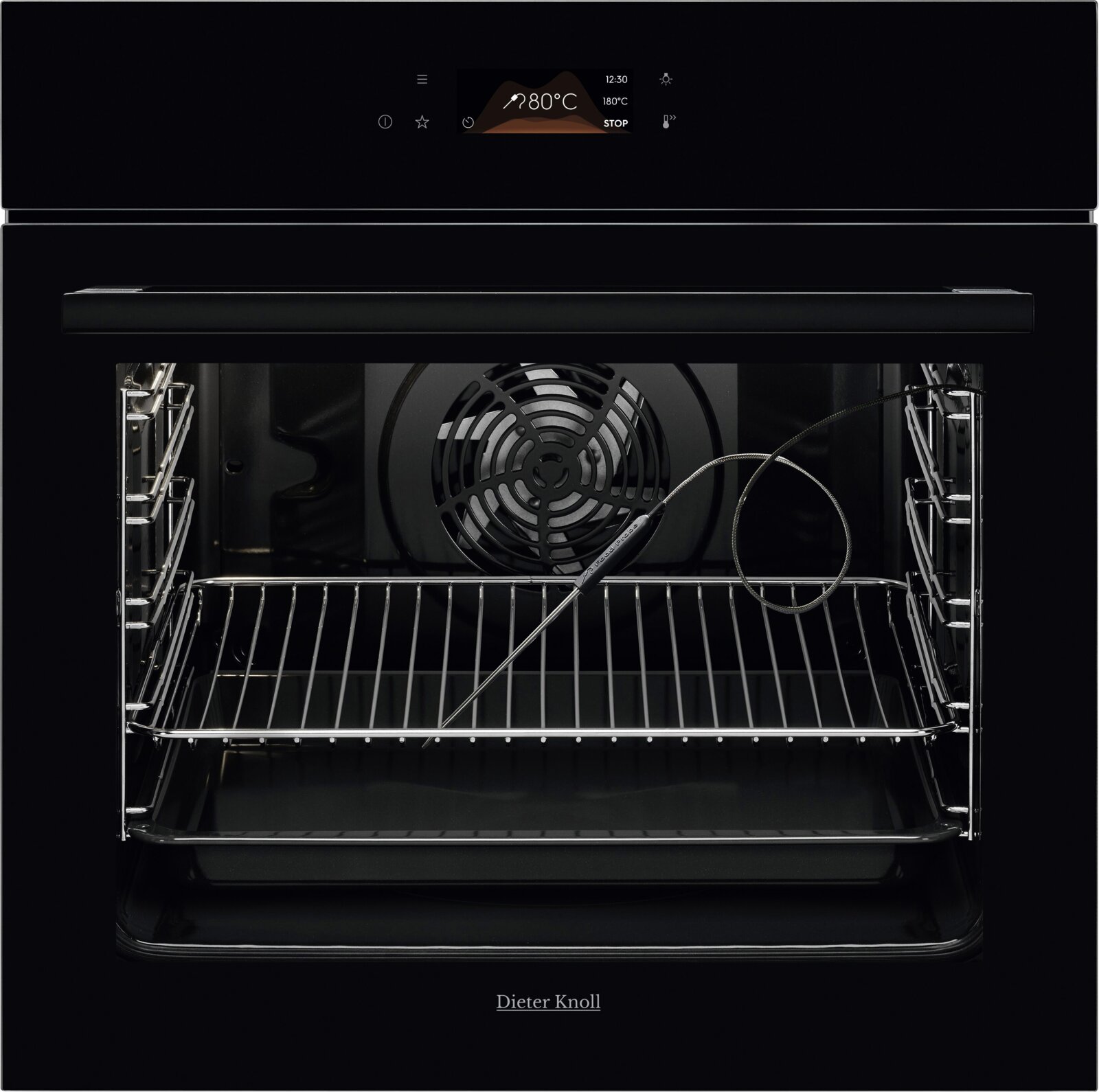 Zwarte inbouwoven met open deur, zicht op ovenruimte met rooster, ventilator en kerntemperatuursonde frontale aanzicht vanuit de voorkant.