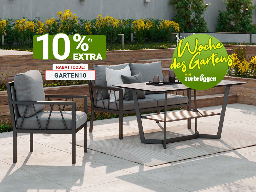 Moderne Outdoor-Lounge mit grauen Polstermöbeln und rechteckigem Gartentisch auf heller Terrasse vor stilvoll angelegtem Garten mit Holzstufen und Pflanzen.