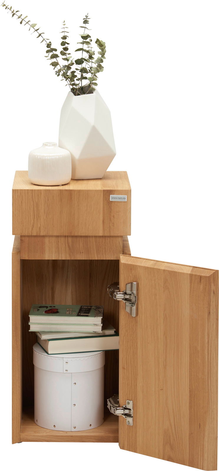 Beistelltisch aus Holz mit geöffneter Tür, darauf zwei weiße Vasen, eine mit Eukalyptuszweigen, aus frontaler Perspektive.