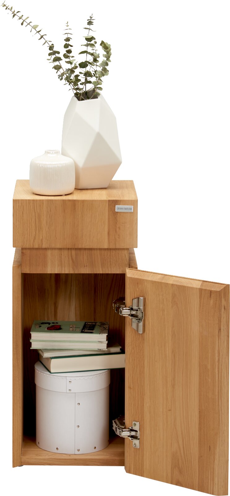 Beistelltisch aus Holz mit geöffneter Tür, darauf zwei weiße Vasen, eine mit Eukalyptuszweigen, aus frontaler Perspektive.