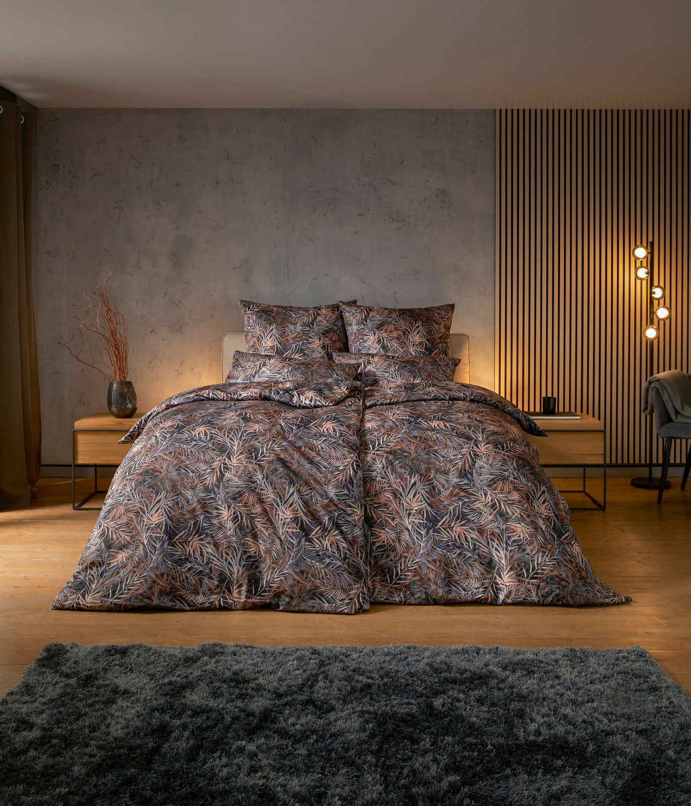 Bettwäsche-Set mit tropischem Blattmuster in einem modernen Schlafzimmer, frontal aufgenommen.