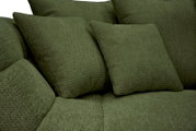 Nahaufnahme in schräger Vorderansicht: grün gepolstertes Sofa mit strukturierter Stoffoberfläche und mehreren weichen Kissen