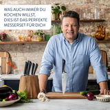 Mann in einer Küche mit einem Schneidebrett und einem Messer, umgeben von frischem Gemüse. Perspektive: Frontalansicht.