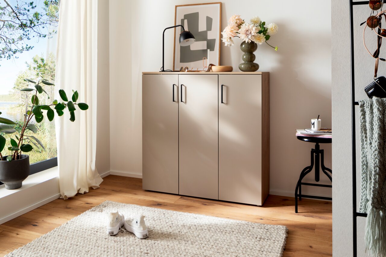 Moderano Schuhschrank breit SHOES Moderner Schuhschrank in einem hellen Raum, frontal fotografiert, mit Dekorationen wie einer Lampe und Blumen auf der Oberseite.