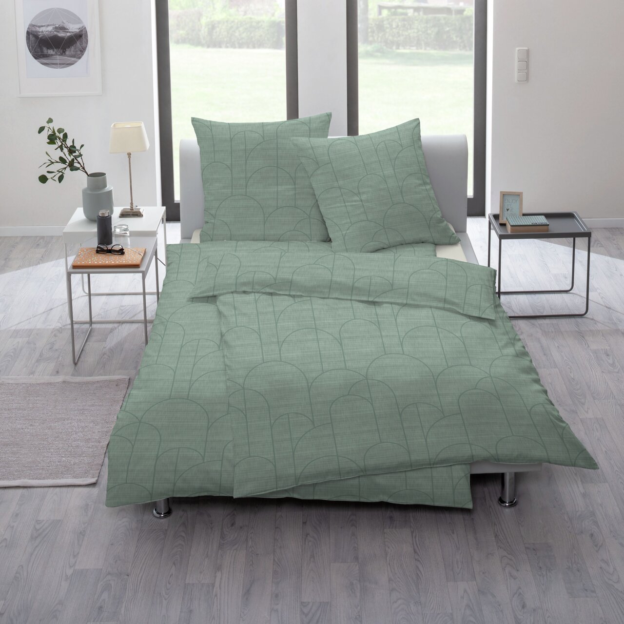Groen beddengoed met een geometrisch patroon op een bed in een moderne slaapkamer, gezien vanuit de zijkant