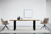 Moderner Esstisch mit massiver Holzplatte und schwarzen Metallbeinen, frontal in Augenhöhe fotografiert, zwischen zwei gepolsterten Drehstühlen in einem minimalistischen Raum.