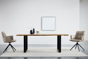 Moderner Esstisch mit massiver Holzplatte und schwarzen Metallbeinen, frontal in Augenhöhe fotografiert, zwischen zwei gepolsterten Drehstühlen in einem minimalistischen Raum.