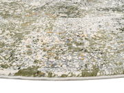 Nahaufnahme eines Designer Teppichs mit abstraktem Muster in Grün- und Grautönen, von der Seite fotografiert.