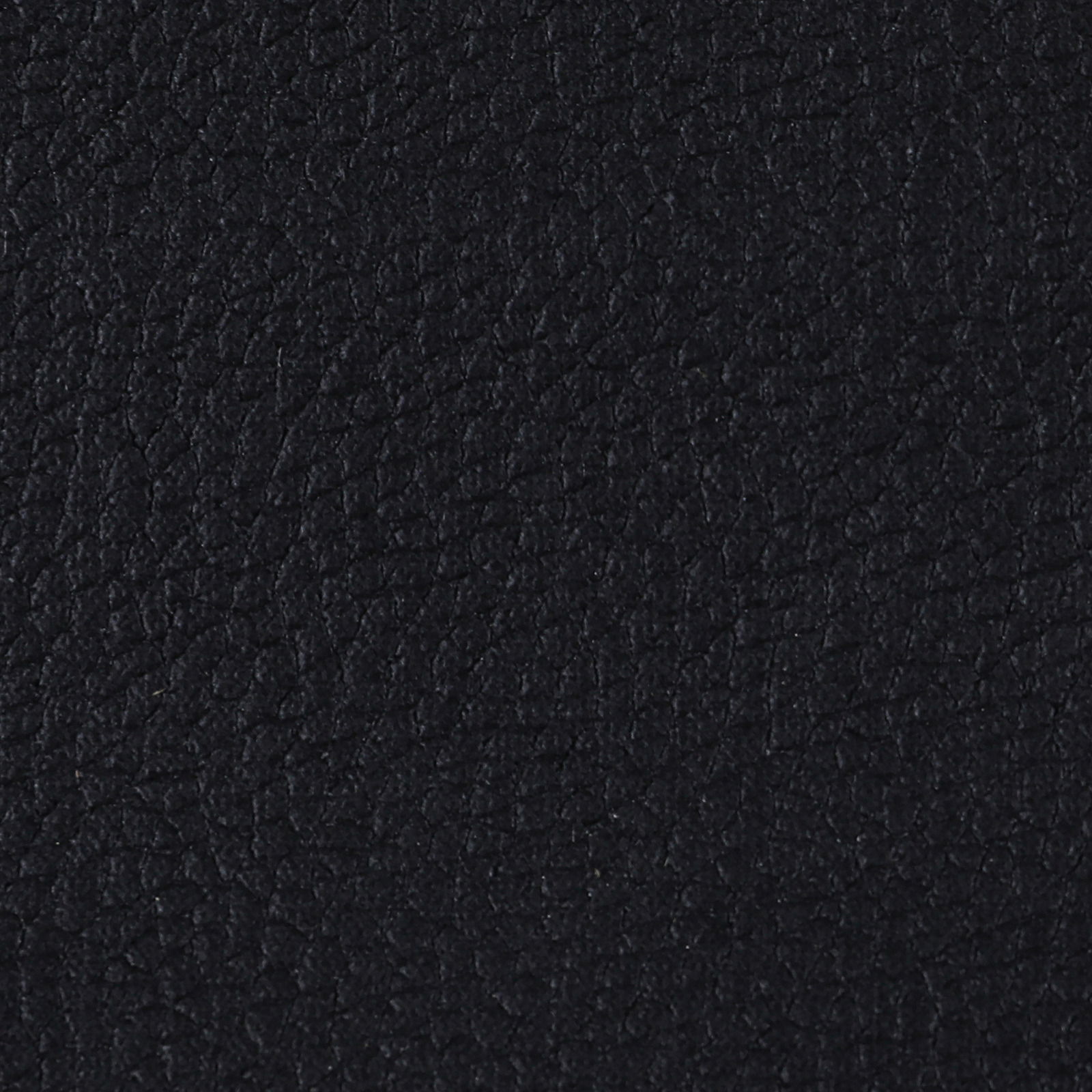 Nahaufnahme der schwarzen Lederstruktur eines Armlehnstuhls